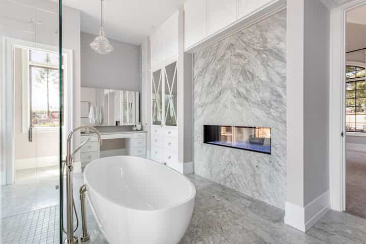 An elegant white bathroom remodeling upgrade with marble fireplace